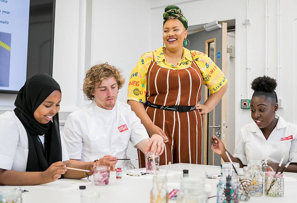 A group of people painting glass jars.