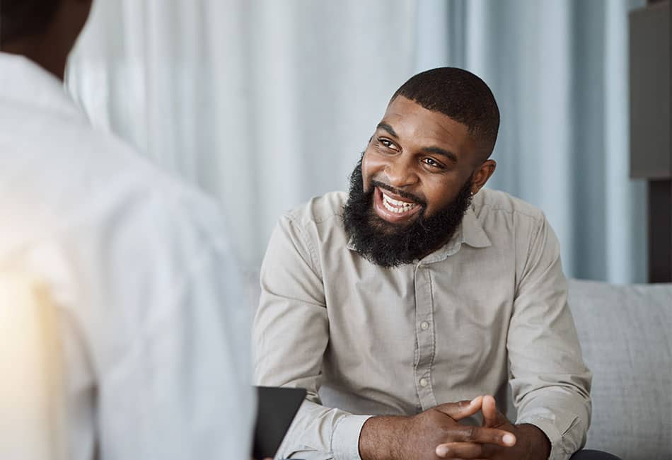 A person talking and smiling at another person.