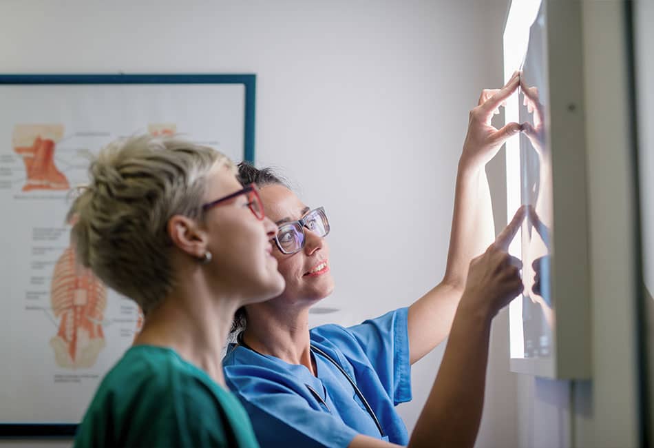 A couple of radiography students in front of the VLA screen.