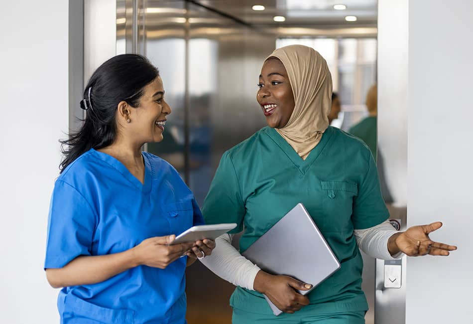 Two people in blue and green uniforms talking to each other.