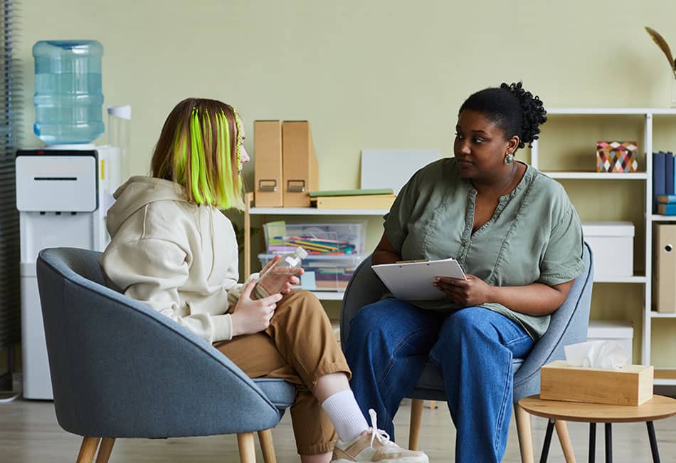 Two people sitting down and talking to each other.